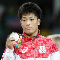 Shinobu Ota stands on the podium after taking the silver medal in the 59-kg Greco-Roman wrestling event on Sunday. | AFP-JIJI