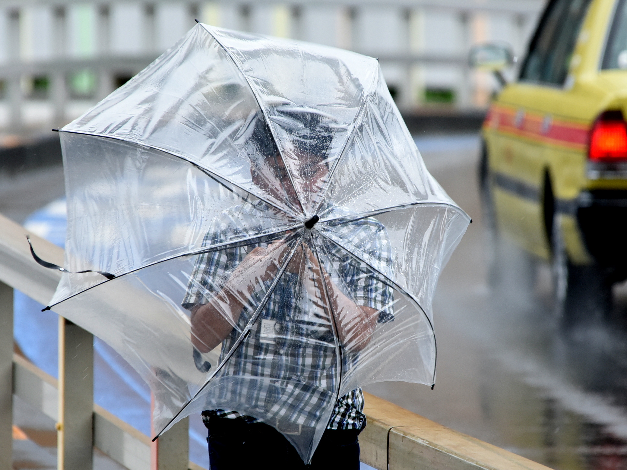 A man's umbrella proves to be no match for the heavy winds of Typhoon Mindulle. | SATOKO KAWASAKI