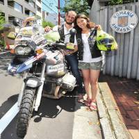 Florin Moraru, 28, and his wife Diana, 26, pose for a photo Wednesday in Tokyo, midway through a journey round the world by motorcycle. They are making the voyage in memory of Dan Dumitru, a Romanian who circled the world on foot 100 years ago. They set off in June and expect to cross 90 nations. Japan is the 19th so far. | YOSHIAKI MIURA