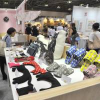 Visitors peruse the giant collection of cat-themed goods during the 82nd Tokyo International Gift Show at Tokyo Big Sight in Koto Ward on Thursday. | YOSHIAKI MIURA
