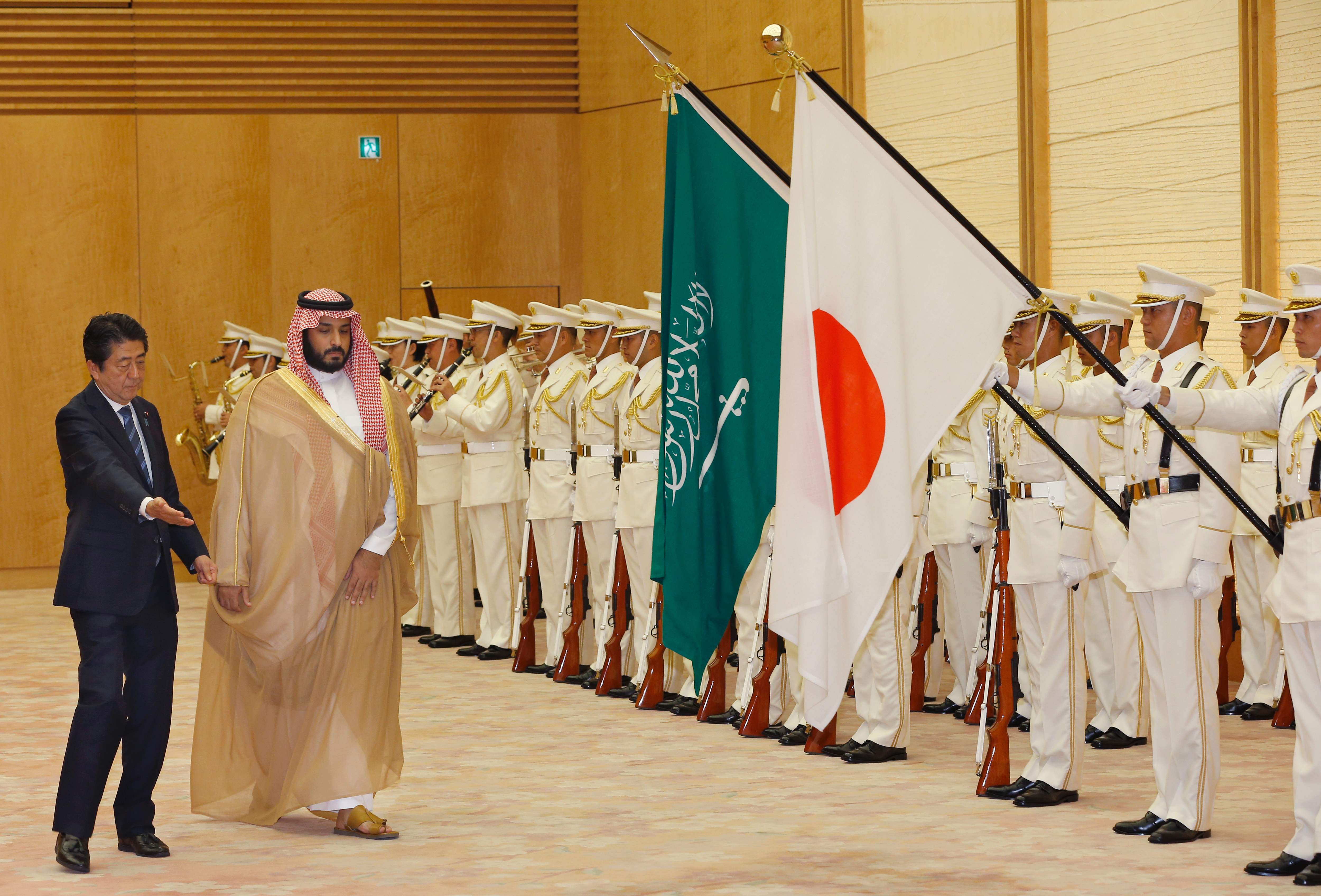 Prime Minister Shinzo Abe escorts visiting Saudi Arabia's Deputy Crown Prince Mohammed bin Salman as they review a guard of honor prior to their meeting at Abe's office in Tokyo on Thursday. | AFP-JIJI
