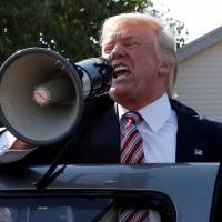 Republican presidential nominee Donald Trump speaks to supporters through a bullhorn during a campaign stop at the Canfield County Fair in Canfield, Ohio, Monday. | REUTERS