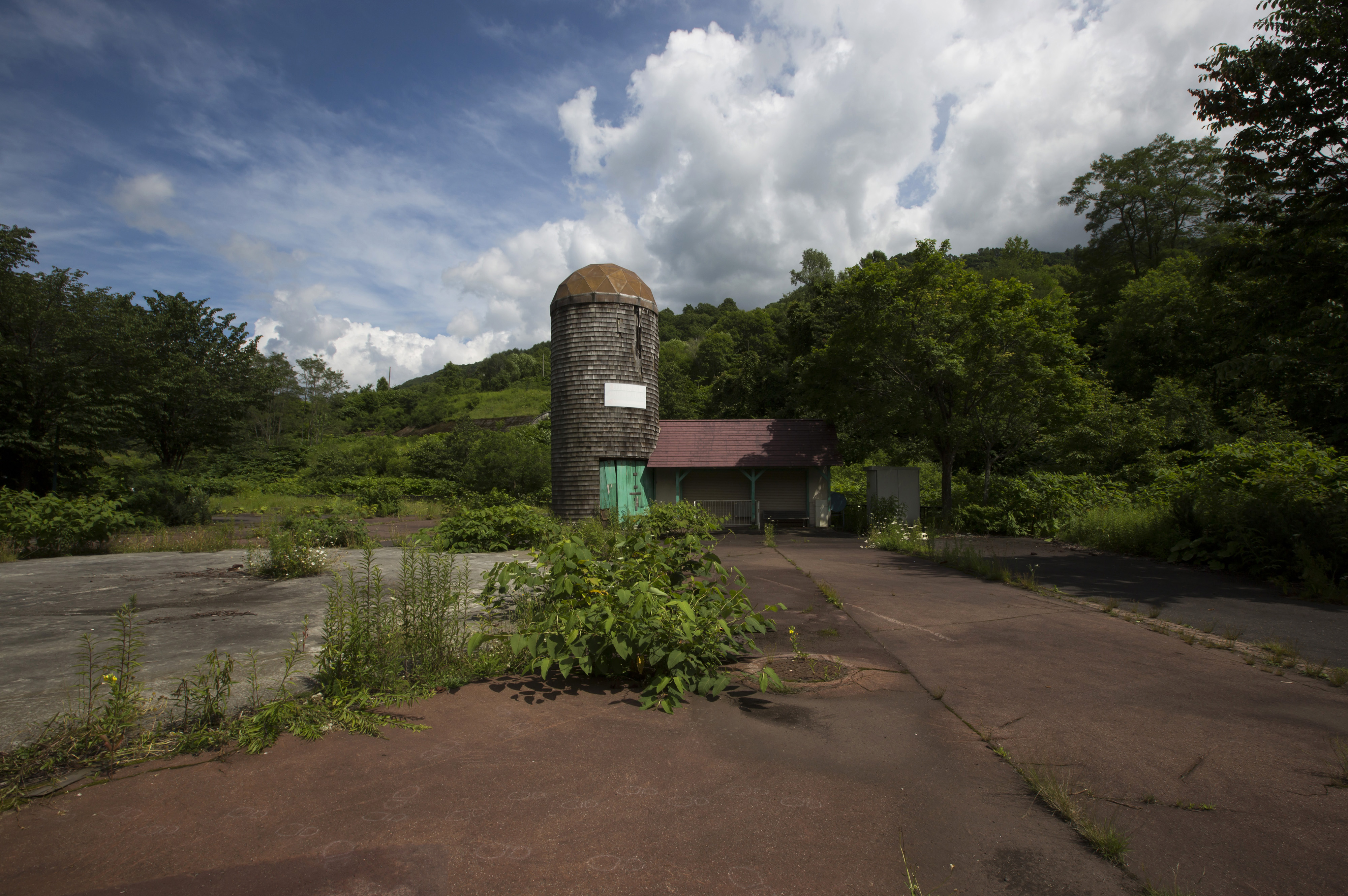 An abandoned building stands at the Coal History Village in the town of Yubari, Hokkaido, on July 21. The bankrupt former mining town is urging its shrunken population to resettle toward its center. | BLOOMBERG