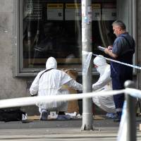 Police forensic experts examine the scene in central Budapest Sunday after an explosion of yet unknown origin occured in a shop late Saturday night. According to an expert, apparently a home made bomb went off in front of the shop. The explosion injured two patrolling policemen. | PETER LAKATOS / MTI VIA AP