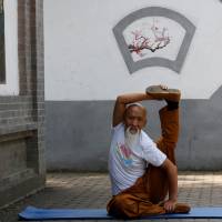 Li Liangui shows off his \"suogugong\" kung fu skills at a park in Beijing on June 30. | REUTERS