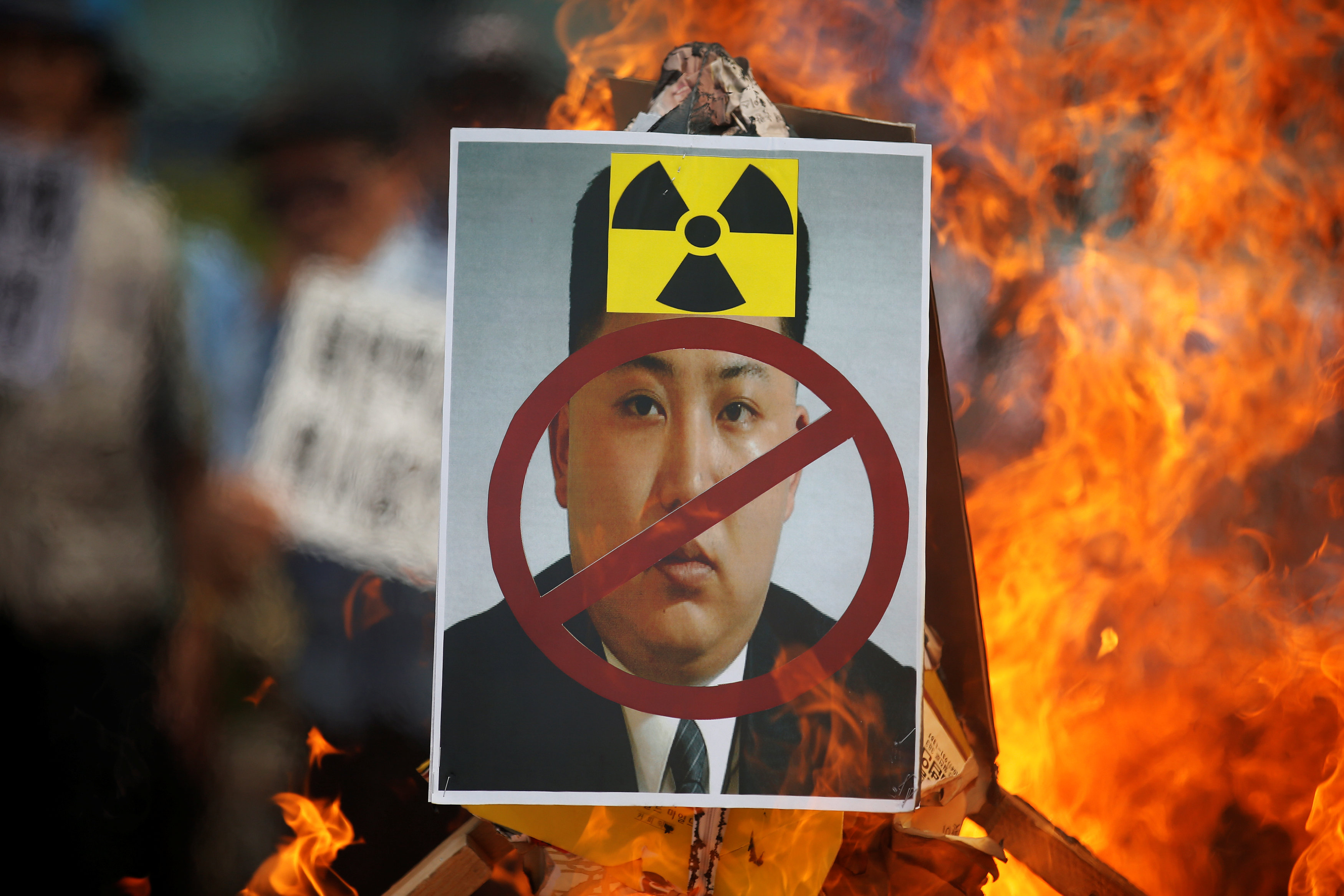 A poster featuring North Korean leader Kim Jong Un is set on fire during an anti-North Korea rally in central Seoul on Saturday. | REUTERS
