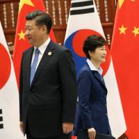 South Korean President Park Geun-hye walks past Chinese leader Xi Jinping during their meeting on the sidelines of the Group of 20 summit at the West Lake State Guest House in Hangzhou, China, on Monday. | REUTERS