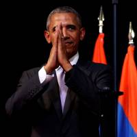 U.S. President Barack Obama holds his hands together and bows at the end of his speech on the sidelines of the ASEAN summit in Vientiane on Tuesday. | REUTERS
