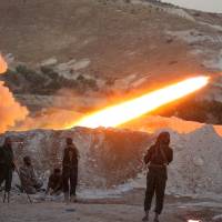 Free Syrian Army fighters launch a Grad rocket from Halfaya town in Hama province, toward forces loyal to Syria\'s President Bashar aAssad stationed in Zein al-Abidin mountain, Syria, Sunday. | REUTERS