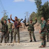 Syrian soldiers gesture Sunday at a location on the southern outskirts of the Syrian city of Aleppo after regime forces retook control of three militaries academies from rebel fighters. | AFP-JIJI