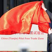 Tianjin municipal Mayor Huang Xingguo unveils a sign reading \"China (Tianjin) Pilot Free Trade Zone\" at a ceremony in Tianjin municipality in April 2015. | REUTERS