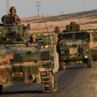Turkish tanks return from the Syrian border town of Jarablus on Friday. | AFP-JIJI