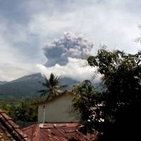 Erupting Mount Barujari is seen from Bayan, Lombok Island, Indonesia, Tuesday. The volcano erupted without warning on Tuesday afternoon, delaying flights from airports on the islands of Lombok and Bali. | AP