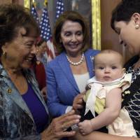 Emily J. Holubowich holds her daughter, Jackie, as she talks with Rep. Nita Lowey, D-N.Y., and House Minority Leader Nancy Pelosi on Capitol Hill in Washington, Wednesday following a news conference about the Zika virus. | AP