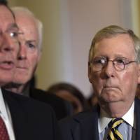 Senate Majority Leader Mitch McConnell listens at right as Sen. John Barrasso speaks during a news conference on Capitol Hill in Washington Wednesday. | AP