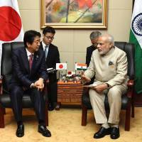 Prime Minister Shinzo Abe and his Indian counterpart, Narendra Modi, hold talks on the sidelines of the Association of Southeast Asian Nations summit in Vientiane on Wednesday. | KYODO