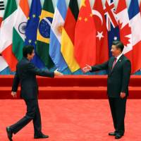 Chinese President Xi Jinping welcomes Prime Minister Shinzo Abe to the Group of 20 summit in Hangzhou, China, on Sept. 4. More Chinese have negative view on Japan-China relations, survey finds