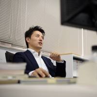 Takahiro Kusakari, chief investment officer of Sawakami Asset Management Inc., sits in front of a computer at the company\'s office in Tokyo on Sept. 2. | BLOOMBERG