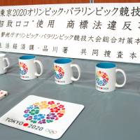 Confiscated items bearing the logo for Tokyo\'s campaign to host the 2020 Olympic Games are shown to the media Wednesday at Shinagawa Police Station in Tokyo. A U.S. language teacher has been arrested over suspected trademark infringement. | KYODO