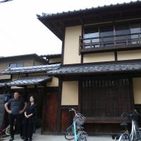 Sae Cardonnel and her French husband, Sylvain, stand in front of their traditional Kyoto \"machiya\" townhouse on June 26. They restored the home with a loan from Kyoto Shinkin Bank. | REUTERS