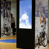People walk past a display of wheelchair basketball at Daimon Station. The Tokyo Metropolitan Government set up displays of 22 Paralympic sports events at 22 stations on the Oedo Line. The Paralympics will run through Sept. 21. | SATOKO KAWASAKI