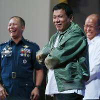 Philippine President Rodrigo Duterte wears a pilot\'s jacket that was presented to him on the anniversary of the 250th Presidential Airlift Wing on Tuesday at the Philippine Air Force headquarters in suburban Pasay city, southeast of Manila, Philippines. On Monday, President Duterte, in his first public statement opposing the presence of American troops, said he wants U.S. forces out of his country\'s south. | AP