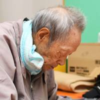 An exhausted elderly man takes a rest at an evacuation center Tuesday in the town of Iwaizumi, Iwate Prefecture. | KYODO