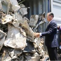 Officials inspect scrap to be returned to Japan at a port in central Thailand in July. | THAILAND\'S MINISTRY OF INDUSTRY / VIA KYODO