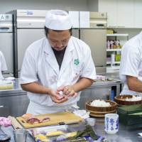 Pressure is on: International students Viet Tran (center) and Anthony Zeidan (right) prepare sushi rolls during a time trial at Tokyo Sushi Academy. Sushi crimes: How Japan polices its culinary traditions