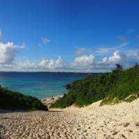 Changing narratives: A woman climbs the sand dunes at Sunayama Beach on Miyako Island, Okinawa Prefecture. Depictions of this island chain as a peaceful, tropical oasis are not entirely accurate. | ISTOCK