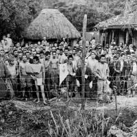 Ongoing struggles: Japanese prisoners stand in a makeshift jail on Okinawa in June 1945. Though the war is over, its effects linger. As former Prefectural Assembly member Keiko Itokazu says of life in modern Okinawa, \"It feels like we are at war.\" | PUBLIC DOMAIN