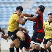 Suntory\'s Ryoto Nakamura (left) carries the ball against Honda in a Top League match on Saturday at Prince Chichibu Memorial Rugby Ground. The Sungoliath routed the Heat 50-0. | KYODO