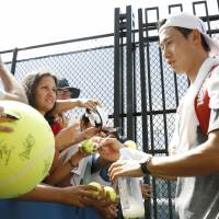Kei Nishikori signs autographs for fans at the U.S. Open on Thursday in New York. | KYODO