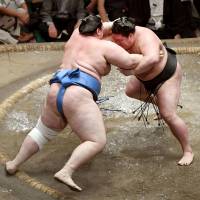 Goeido (right) grapples with Aoiyama at the Autumn Grand Sumo Tournament at Ryogoku Kokugikan on Monday. | KYODO