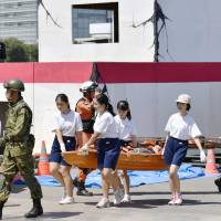 Students take part in a disaster drill with SDF troops in the city of Saitama on Thursday, which was marked as Disaster Prevention Day. The government held a nationwide drill, while local authorities conducted their own exercises involving around 1 million people. | KYODO