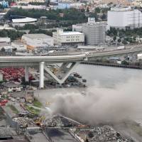 Smoke rises from an industrial waste dump in Osaka, about 1 km west of Universal Studios Japan, after metal waste and other materials caught fire on Thursday. The theme park stayed open but the cause of the fire is under investigation. | KYODO