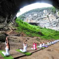 Yoga enthusiasts practice at Yueyan Cave during a session organized by a yoga club in Daoxian, Hunan province, China, on Sunday. | REUTERS