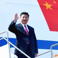Chinese President Xi Jinping waves as he arrives in Dhaka on Friday. | AFP-JIJI