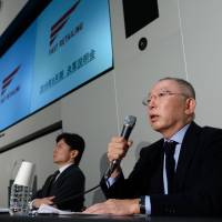 Tadashi Yanai (right), chairman and chief executive officer of Fast Retailing Co., speaks during a news conference in Tokyo on Thursday. The company reported its lowest income for the year to August since 2008. | BLOOMBERG