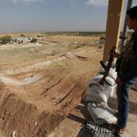 A rebel fighter stands on a lookout point in Kafr-Brisha village, northern Aleppo countryside, Syria, Tuesday. | REUTERS