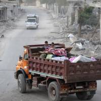 People who fled Islamic State areas travel on the back of a vehicle in al-Rai town, northern Aleppo countryside, Syria, Tuesday. | REUTERS