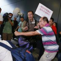 A pro-democracy protester (left) falls during a scuffle with pro-Beijing supporters (right) outside the Legislative Council in Hong Kong on Wednesday. | AP