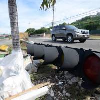 A Jamaican man stands next to a stoplight that has been taken down in St. Andrew by the National Works Agency in preparation of Hurricane Matthew on Sunday. Hurricane Matthew, the most powerful Caribbean storm in a decade, churned toward Jamaica and Haiti on a path that forecasters said could eventually take it to the Eastern United States. | AFP-JIJI