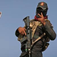 A member of the Iraqi security forces flashes the victory sign Tuesday in the village of Shaqouli, about 35 km east of the Islamic State-held city of Mosul, Iraq. | AFP-JIJI