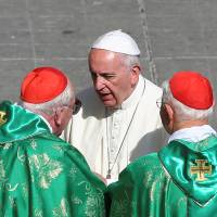 Pope Francis speaks with two cardinals before leaving St. Peter\'s Square in the Vatican at the end of a Marian vigil Mass on Sunday. | REUTERS