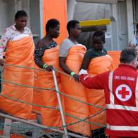 Women disembark in Sicily from the Siem Pilot on Monday after rescue operations of migrants at sea during the weekend. | AFP-JIJI