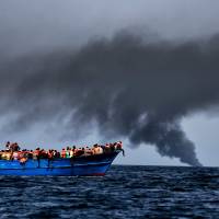 Migrants wait to be rescued as they drift at sunset in the Mediterranean ome 20 nautical miles north off the coast of Libya on Monday. | AFP-JIJI