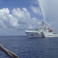 A Chinese coast guard vessel approaches Filipino fishermen during a confrontation over Scarborough Shoal in the South China Sea in September 2015. Philippines says China still guarding key shoal but Filipino fisherman back