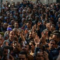 Participants stand in front of the municipality headquarters in Diyarbakir, southeastern Turkey, on Sunday during a pro-Kurdish demonstration. A Turkish court has barred Figen Yuksekdag, a leader of the main pro-Kurdish party, from leaving the country, accusing her of \"belonging to an armed terrorist organisation,\" the state-run Anadolu news agency reported on Saturday. | AFP-JIJI