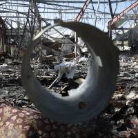A forensic expert inspects a funeral hall in Sanaa on Monday, two days after it was hit by a deadly Saudi-led airstrike. | AP